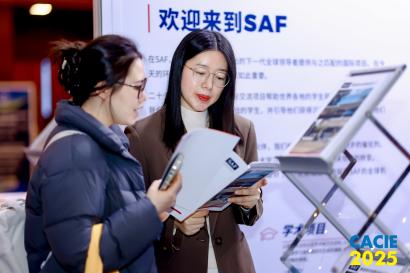 An SAF China staff member shows someone informational materials at CACIE 2025 in Beijing.