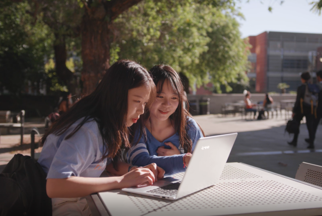 加州大学洛杉矶分校校园里使用笔记本电脑的学生