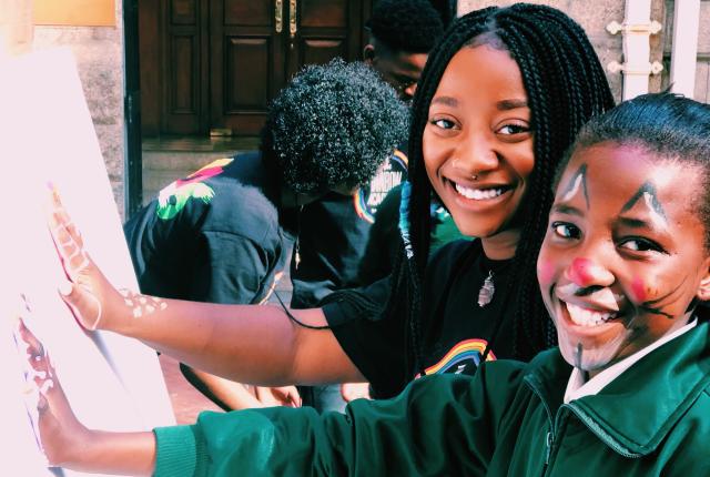 a student intern painting with a student