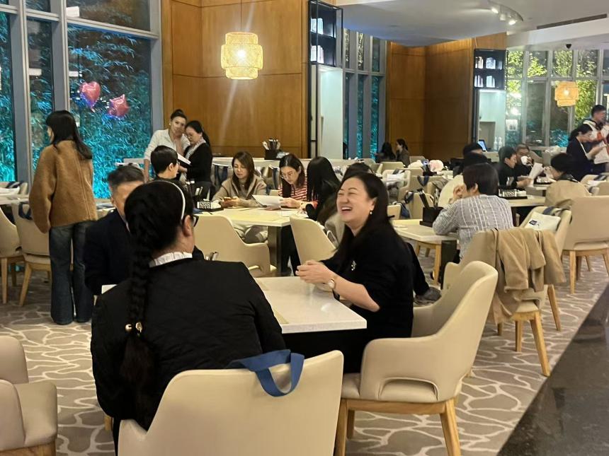 A woman attending the SAF reception dinner at CACIE 2025 laughs at a table with a colleague. 