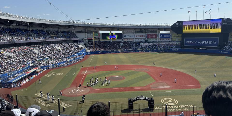 A baseball field and game as seen from the stands.